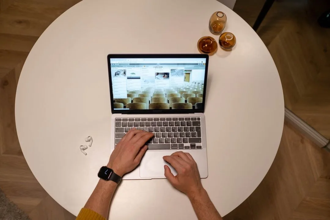 Person using a laptop to look up information at a table.