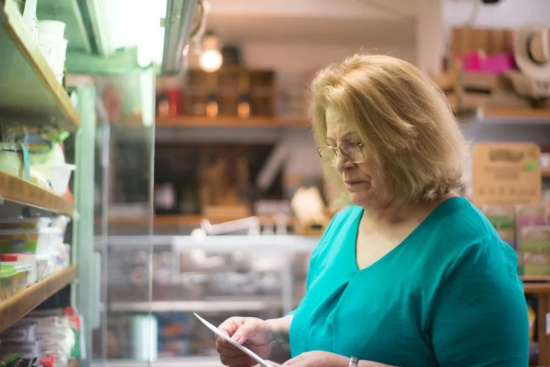 Woman considering products while shopping in a grocery store.