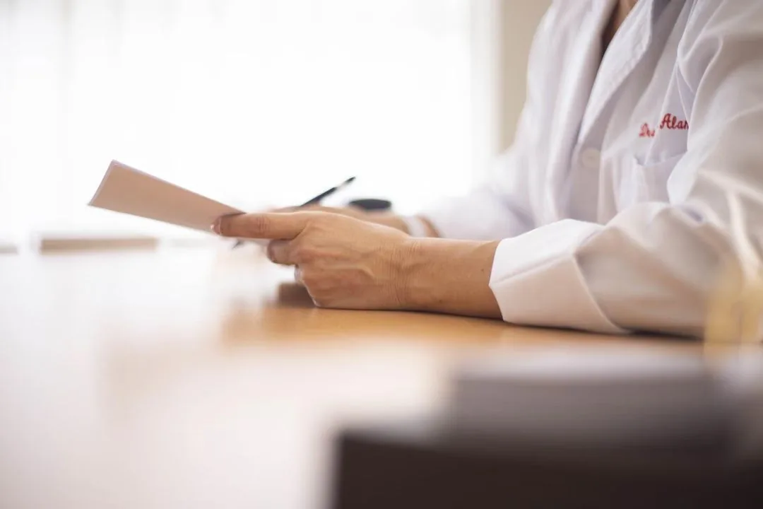 Clinician in a white coat reviewing a document.