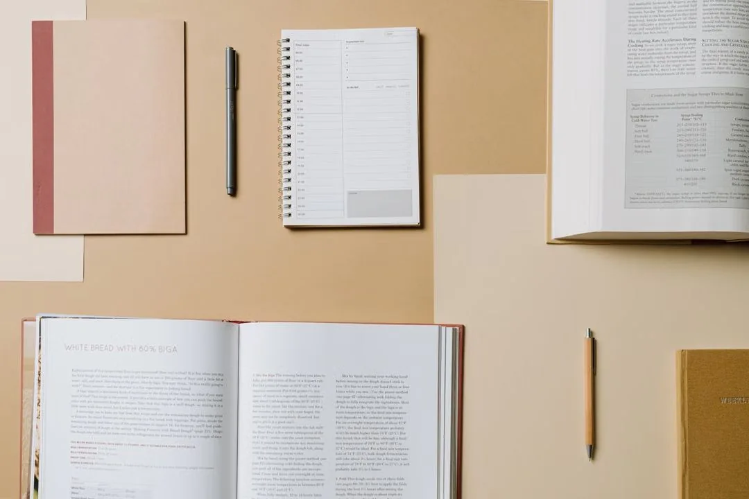 Open books and notebooks laid out on a desk.