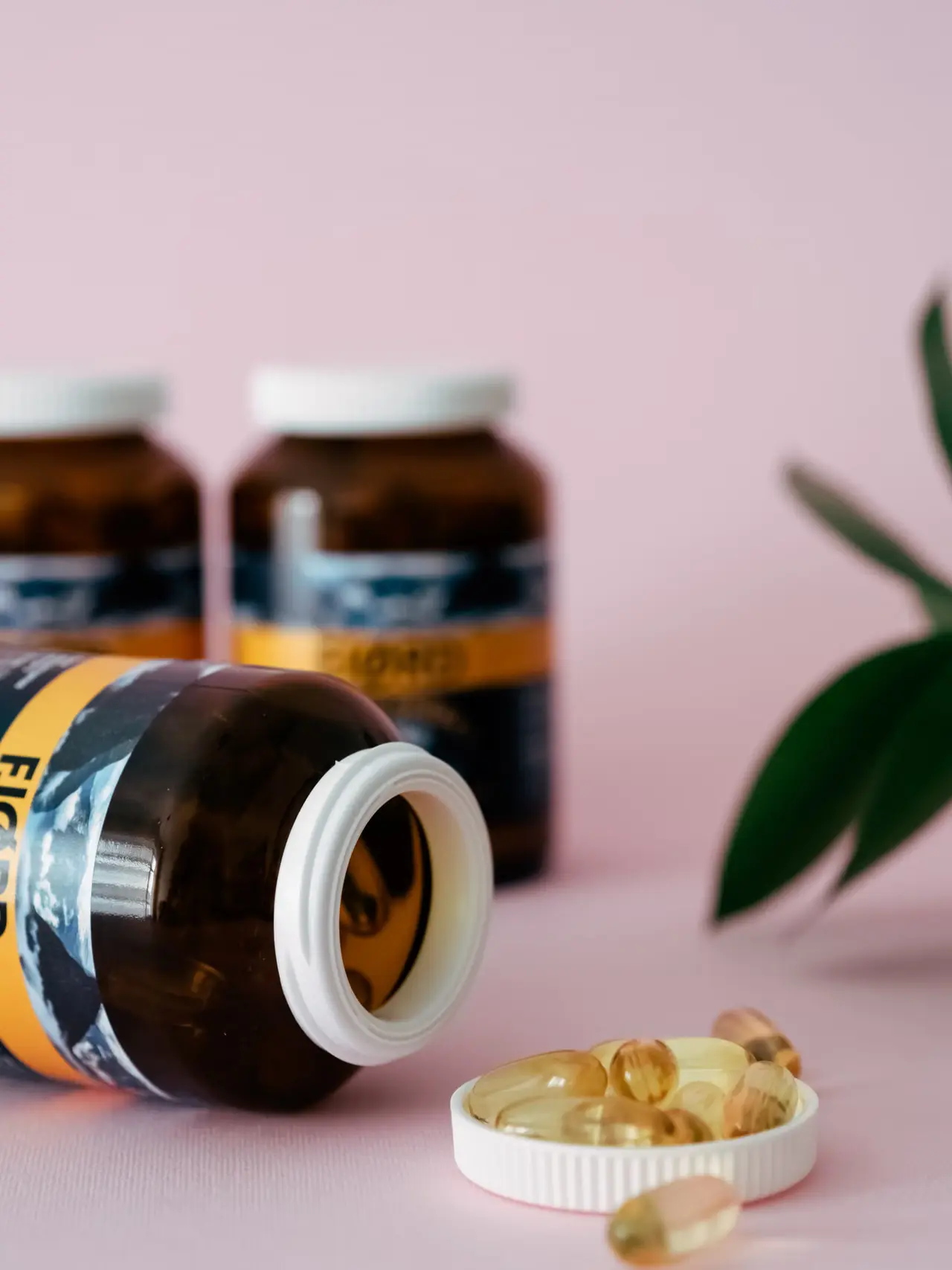 Supplement bottles and capsules arranged on a clean wellness surface.