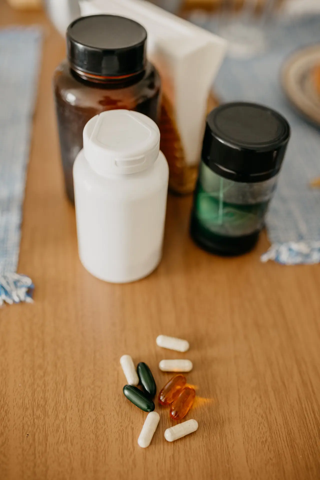 Assorted vitamin and supplement bottles with capsules.