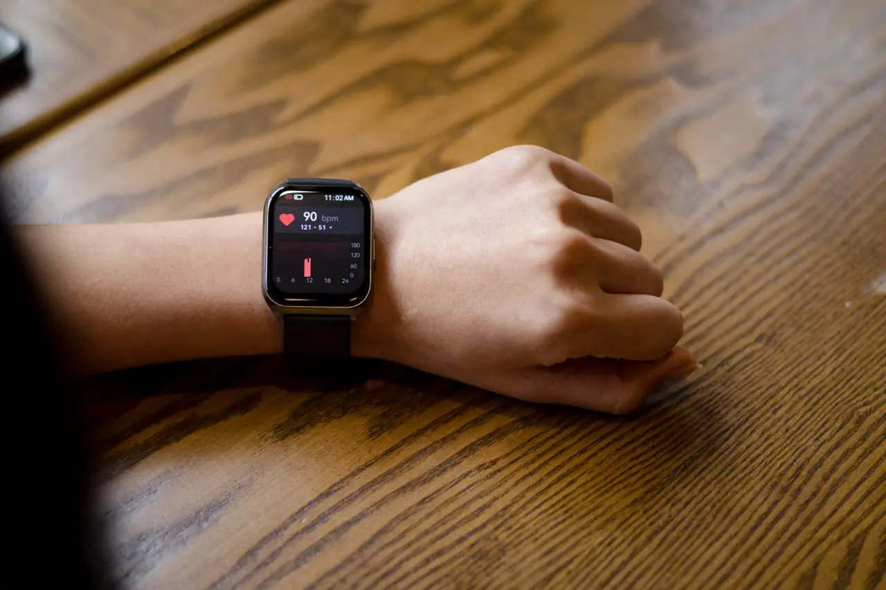 Smartwatch displaying a heart-rate reading on a wrist.