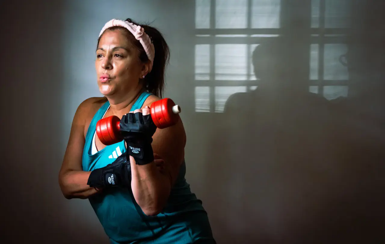 Middle-aged woman lifting a dumbbell during strength training.
