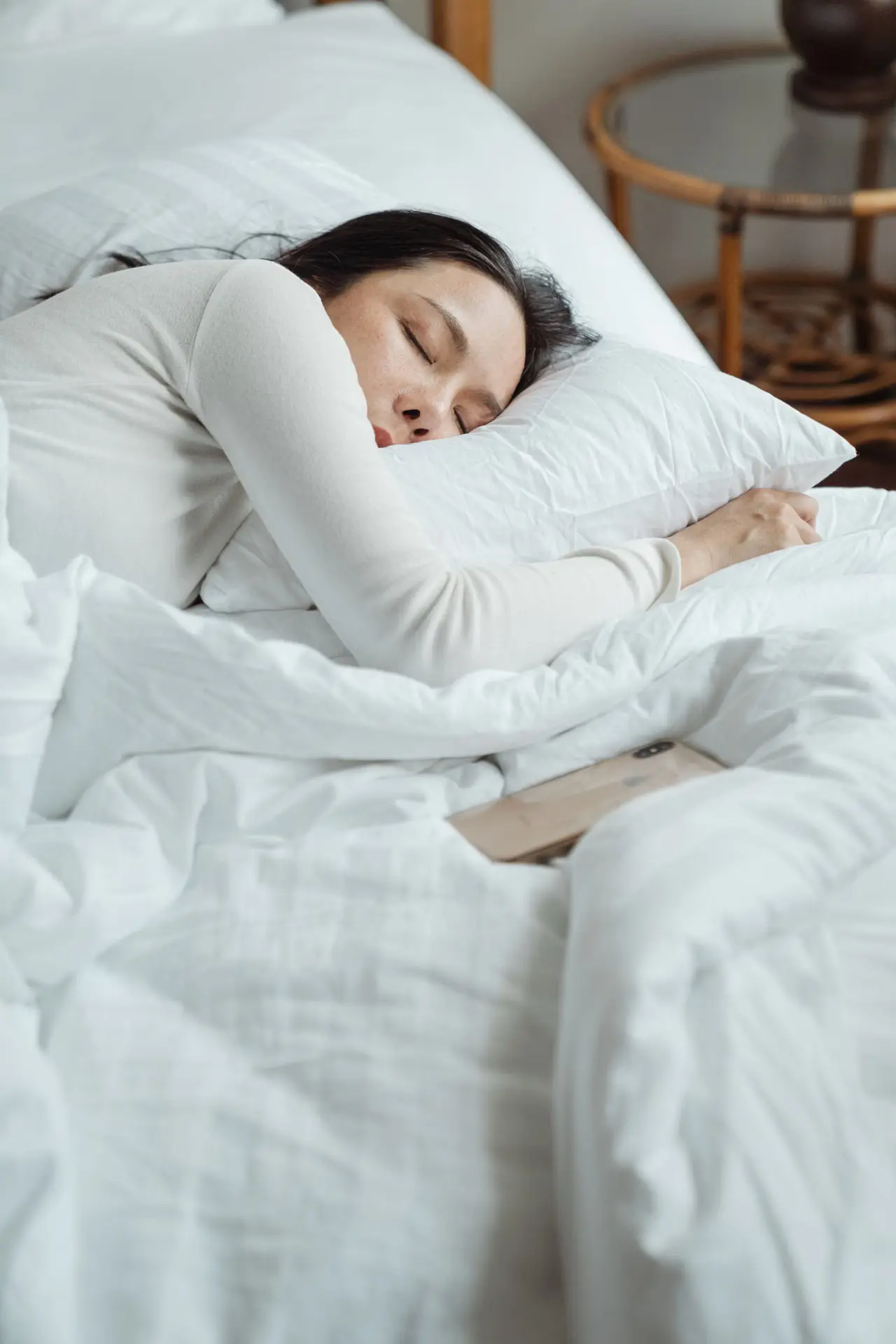 Woman sleeping in a bed with white bedding