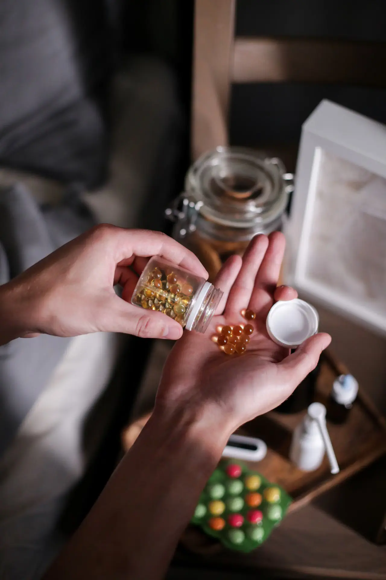 Hands holding vitamin capsules during a daily supplement routine.