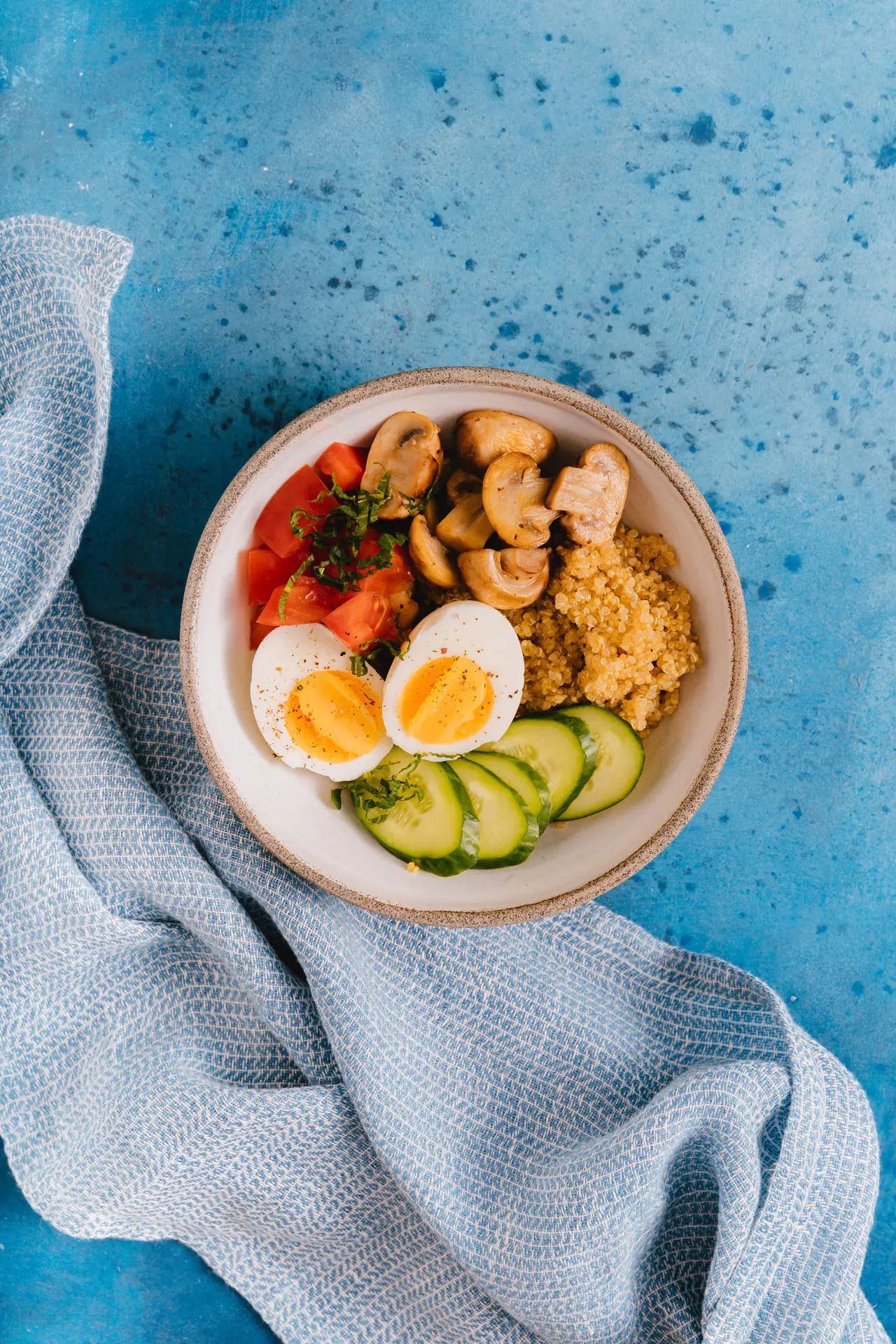 Healthy bowl with eggs, quinoa and vegetables.